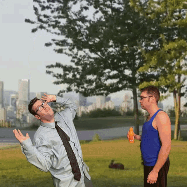 a man in a blue tank top holds an orange juice bottle