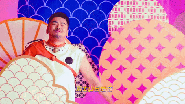 a man is dancing in front of a colorful background with chinese characters