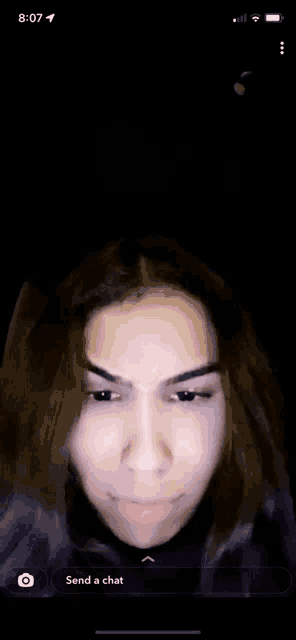 a woman 's face is visible on a phone screen .