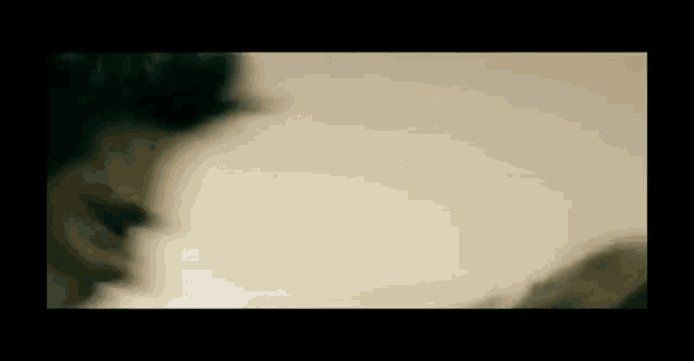 a blurry picture of a person laying on a bed with a white blanket .