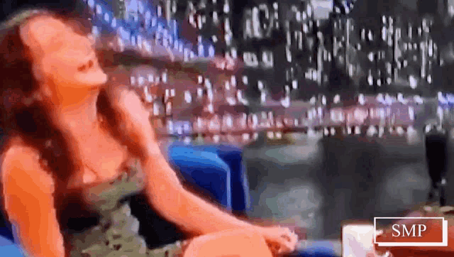 a blurry picture of a woman sitting in a chair with the word smp in the corner