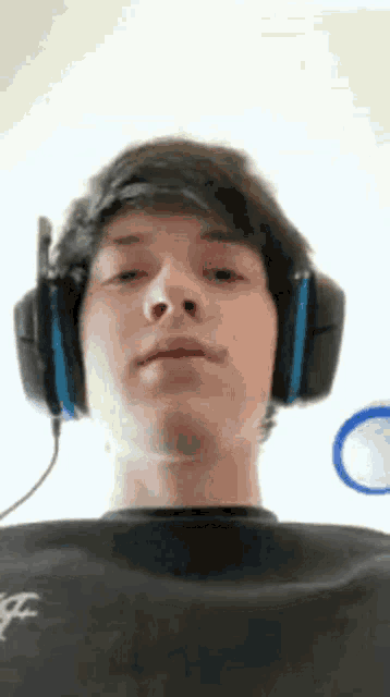 a young man wearing headphones and a black shirt .