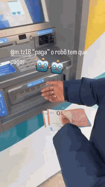a person taking money out of an atm machine with a robot sticker on it