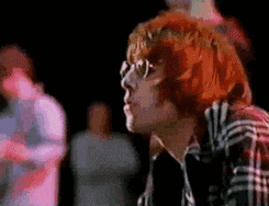 a man with red hair wearing glasses and a plaid shirt
