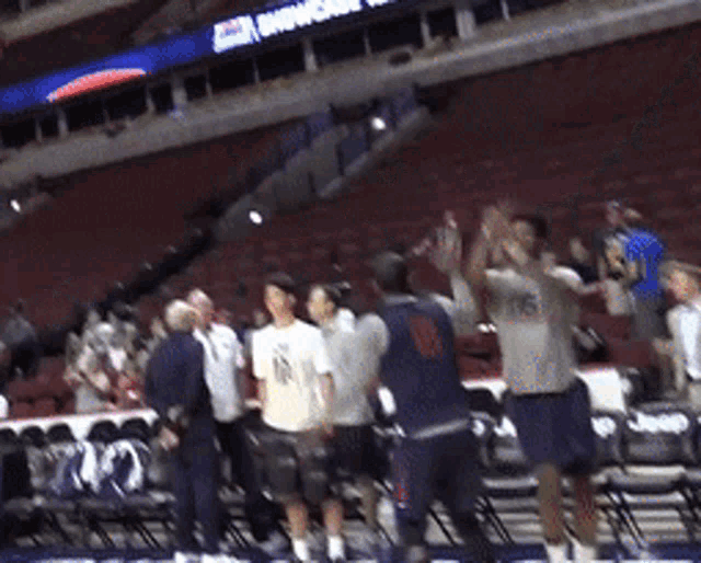 a group of people are standing in a stadium with a sign that says ' washington ' on it