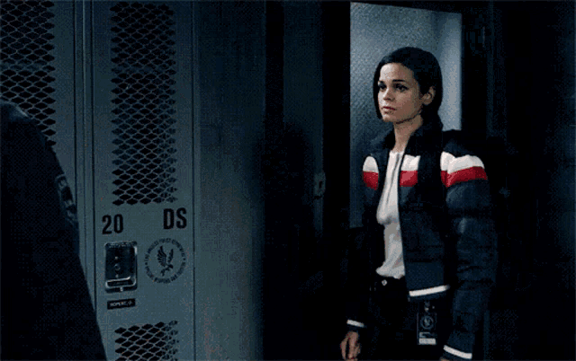a man and a woman are kissing in front of lockers with the number 34 on them