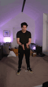 a man in a black shirt and black pants is standing in a room