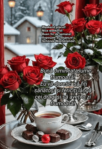 a bouquet of red roses sits next to a cup of coffee and chocolates