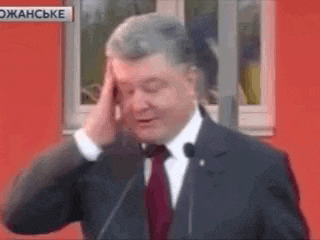 a man in a suit and tie is holding his head .