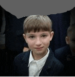 a young boy in a suit and white shirt is standing next to a group of people .