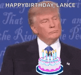 a man in a suit and tie is holding a birthday cake with candles on it .