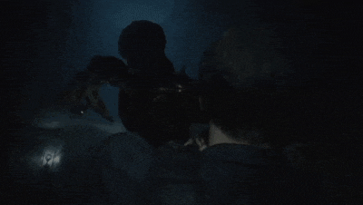 a man in a police uniform is standing next to a monster in a dark room in a video game .