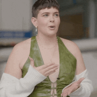 a woman is wearing a green leather top and a white sweater .