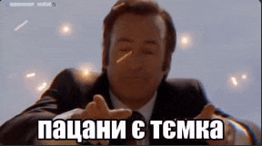 a man in a suit is making a funny face with his hands outstretched in front of him .