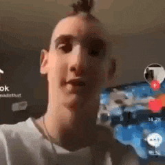 a man with a mohawk is looking at the camera in a video .