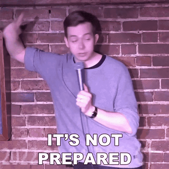 a man stands in front of a brick wall holding a microphone and says " it 's not prepared "