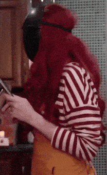 a woman with red hair wearing a striped shirt and an apron