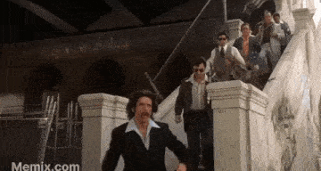 a group of men are walking down stairs .