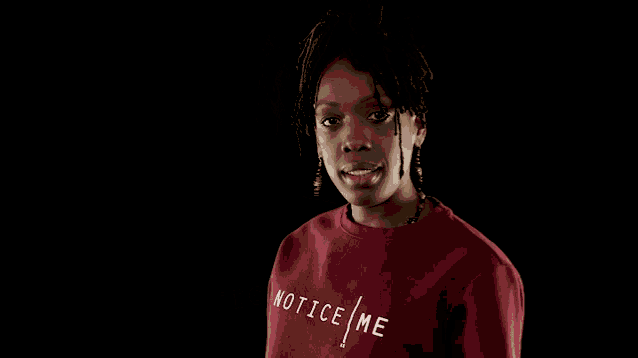 a woman wearing a red shirt that says notice me on it