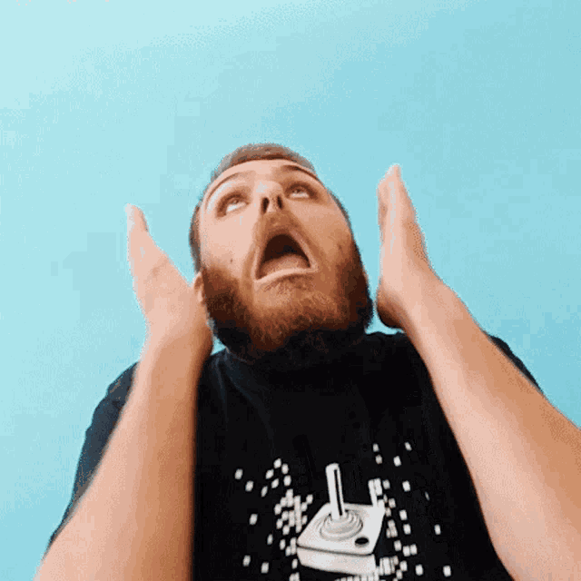 a man with a beard is wearing a black t-shirt that says atari