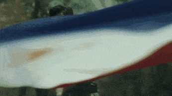 a man is holding a blue white and red flag in his hands .