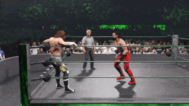 two wrestlers in a ring with a referee in the background