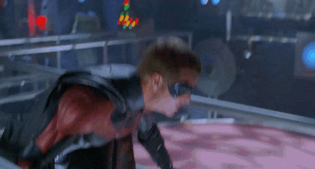 a man in a red and black superhero costume is crawling on the ground