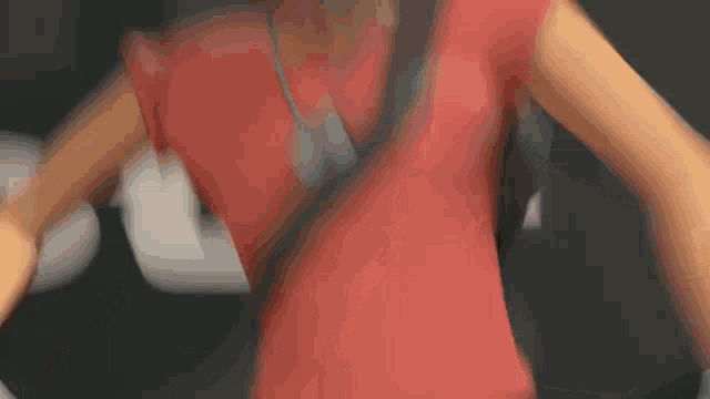 a close up of a person wearing a red shirt with a black strap around their waist .