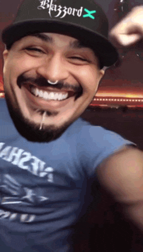 a man wearing a hat that says blazzard x is smiling