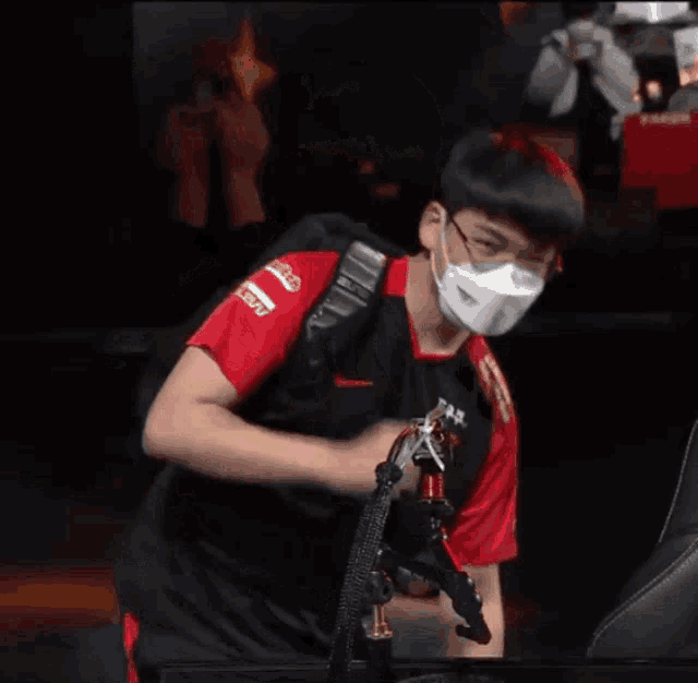 a man wearing a mask and a red shirt that says tf7