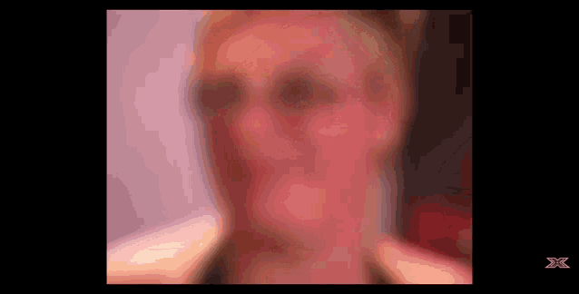 a blurry picture of a woman 's face with an x on the bottom
