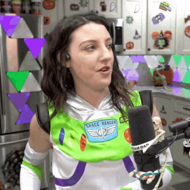 a woman dressed in a space ranger costume holds a microphone