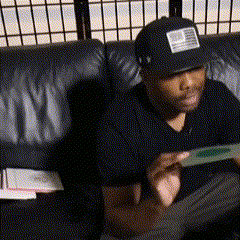 a man sitting on a couch wearing a hat with a united states flag on it