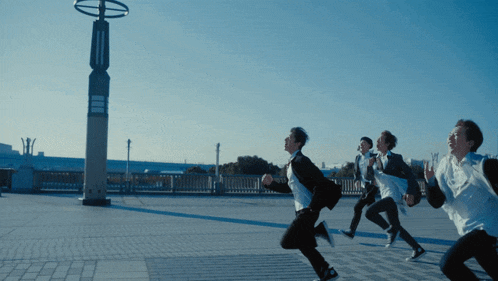a group of young men are running in a row
