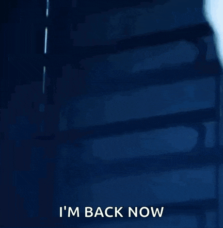 a cartoon character is standing in the dark with the words `` i 'm back now '' written below it .