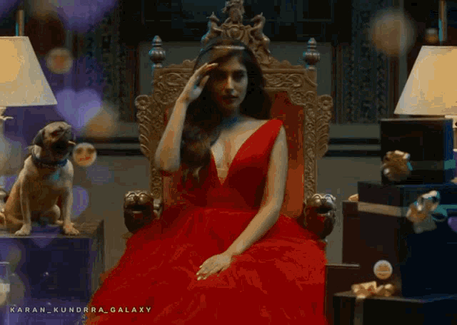a woman in a red dress is sitting on a throne with a dog behind her