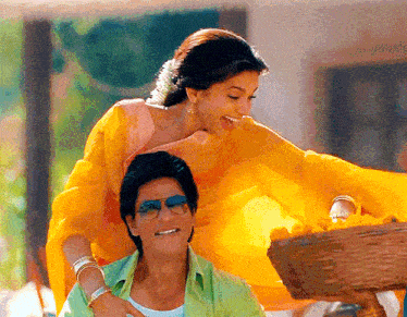 a man in a green shirt is sitting next to a woman in a yellow dress .