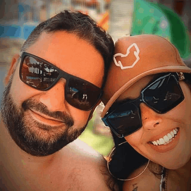 a man wearing sunglasses and a woman wearing a brown hat with a heart on it