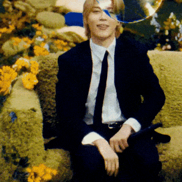 a man in a suit and tie is sitting on a green couch