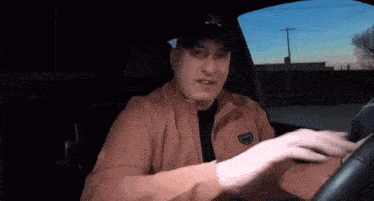 a man wearing a new york yankees hat is sitting in a car