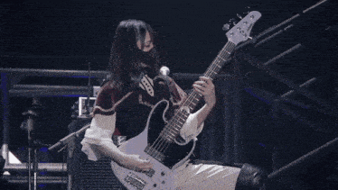 a blurred image of a person playing a guitar in a dark room