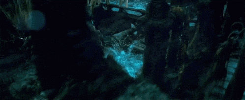 a man in a pirate outfit is holding a woman 's hand in a dark room .