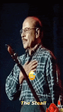 a man in a plaid shirt is holding a guitar and says the steal on the bottom