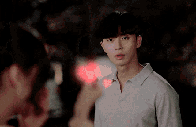a man in a white shirt is looking at a woman in a red heart shaped object