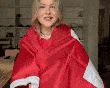 a blonde woman is wrapped in a red and white flag