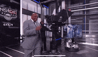a man in a suit is standing in front of a camera with a sign that says nsde on it