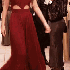 a woman in a red dress is dancing with a man in a black jacket .