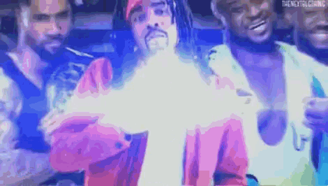a group of men are standing next to each other in a dark room and one of them is holding a glowing object .
