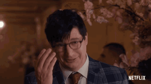 a man in a suit and tie with a netflix logo on the bottom right