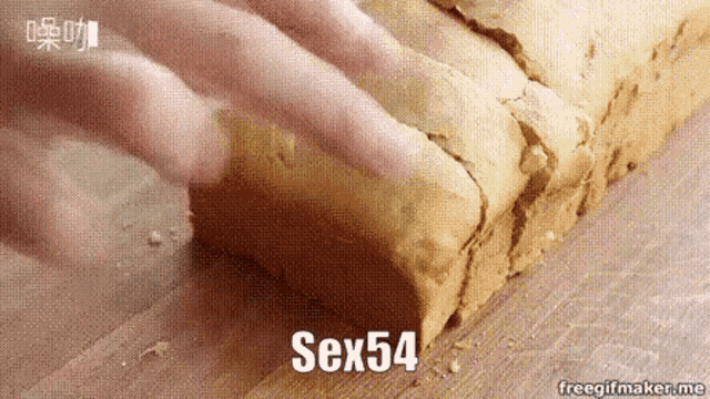 a person is cutting a loaf of bread on a cutting board with the words sex54 written on it .